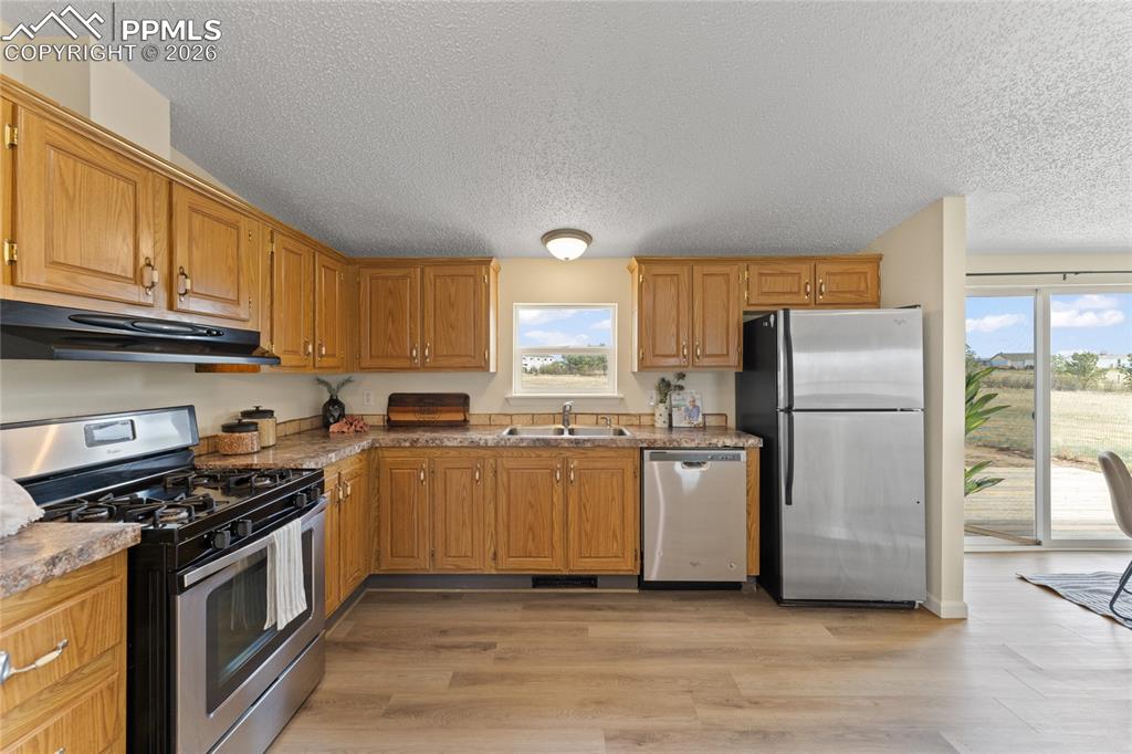 5505 Whipshaw Road Peyton, CO 80831 - Photo 12 of 39 a kitchen with a refrigerator stove and wooden cabinets