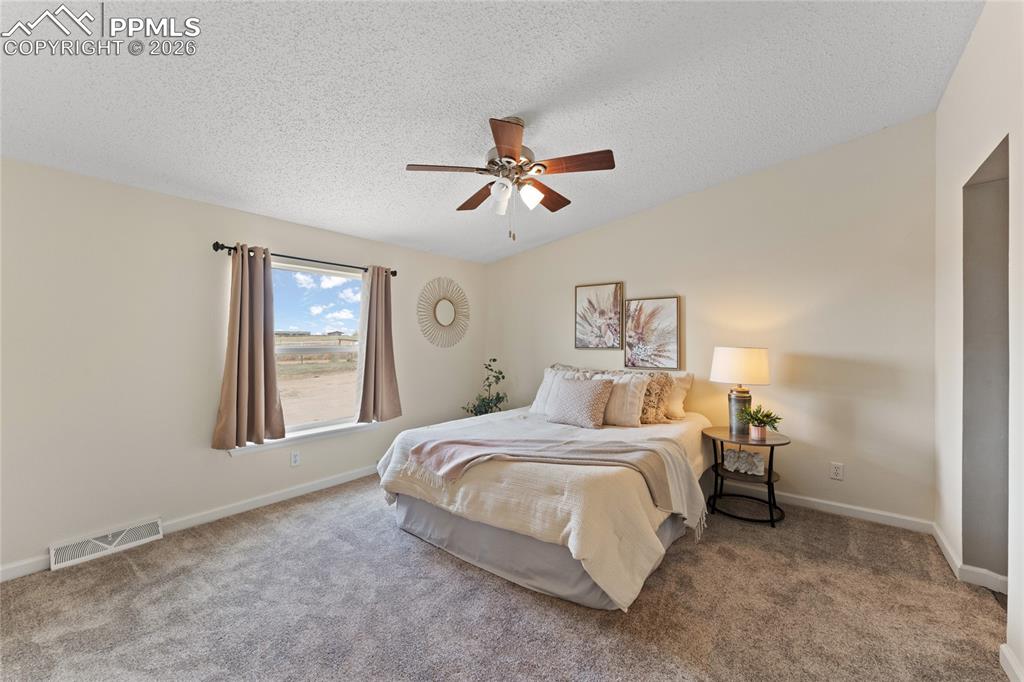 5505 Whipshaw Road Peyton, CO 80831 - Photo 15 of 39 a bedroom with a bed and a chandelier