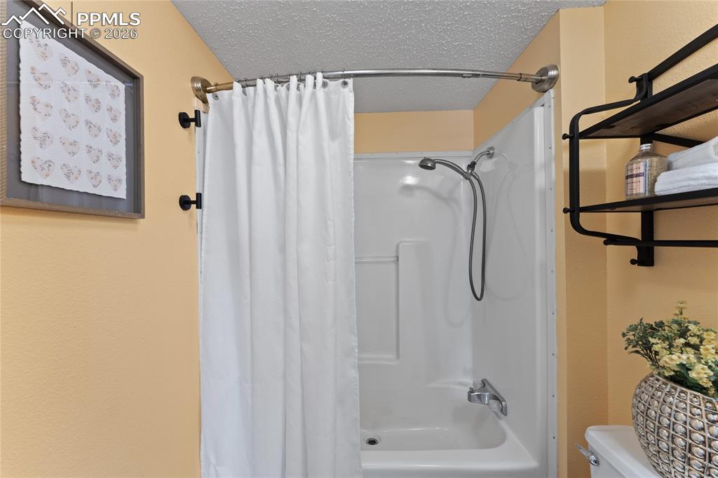 5505 Whipshaw Road Peyton, CO 80831 - Photo 31 of 39 a bathroom with a shower curtain and a bathtub