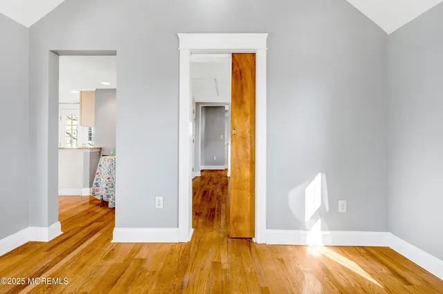 a view of a bedroom with a bed and wooden floor