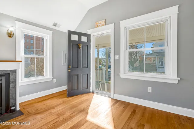a view of an empty room with window and a kitchen