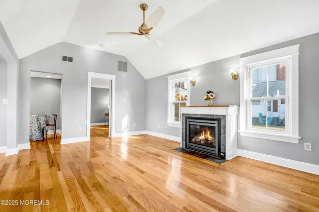 a view of empty room with a fireplace and wooden floor