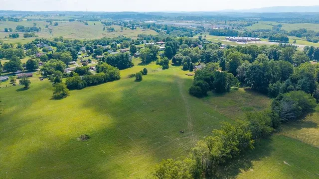 an aerial view of residential houses with outdoor space and trees