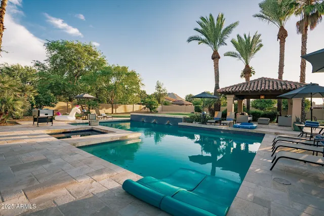 a swimming pool view with a seating space and a garden