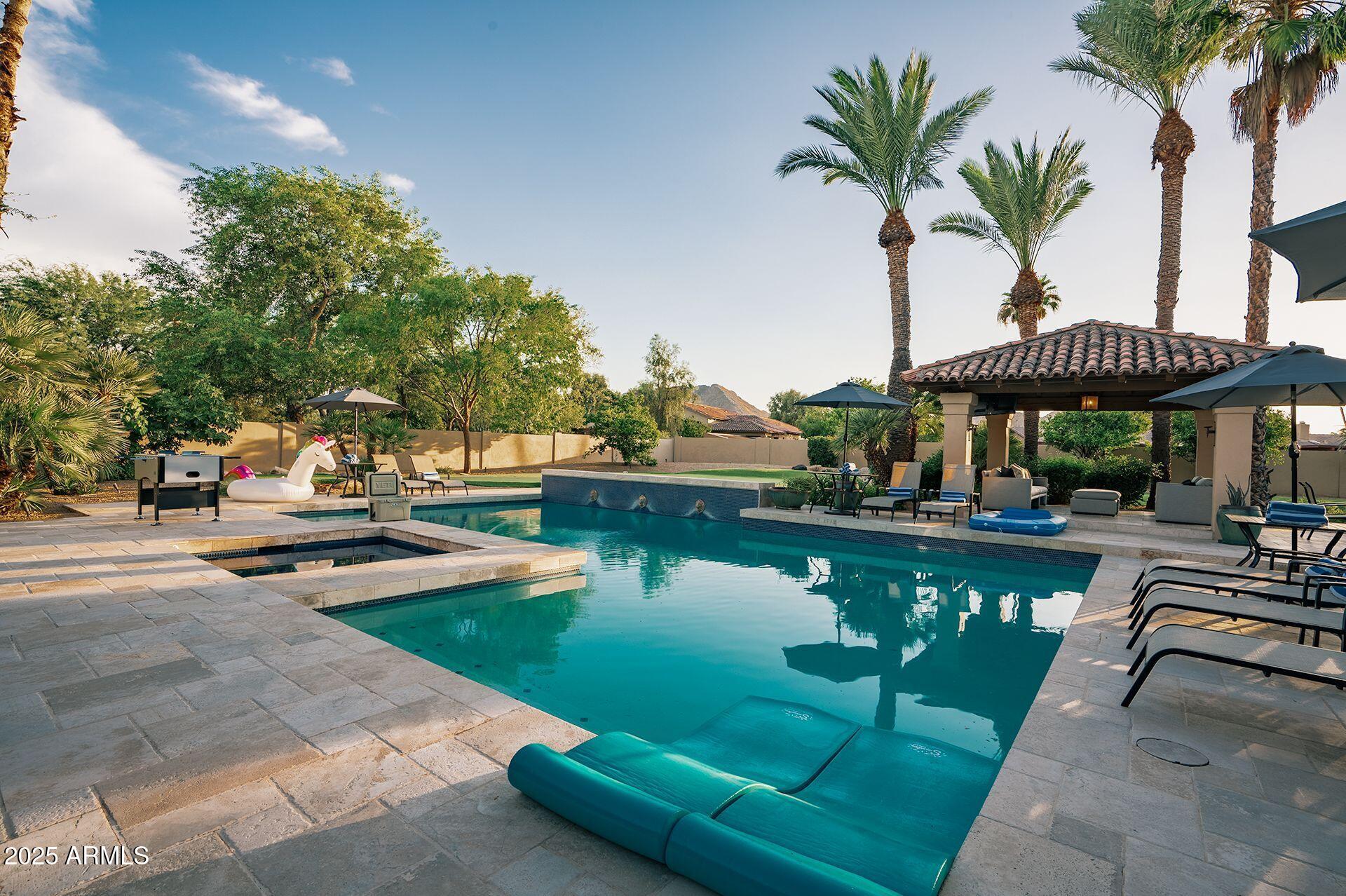 a swimming pool view with a seating space and a garden