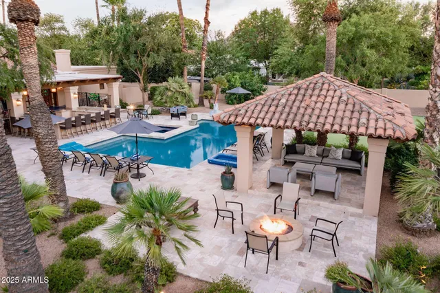 a view of a patio with couches table and chairs under an umbrella
