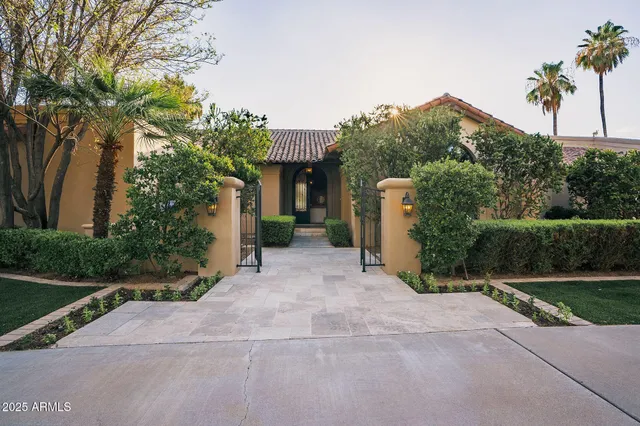 a view of a house with a yard and basketball court