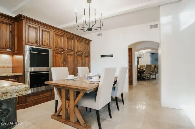a dining room with furniture a chandelier and window