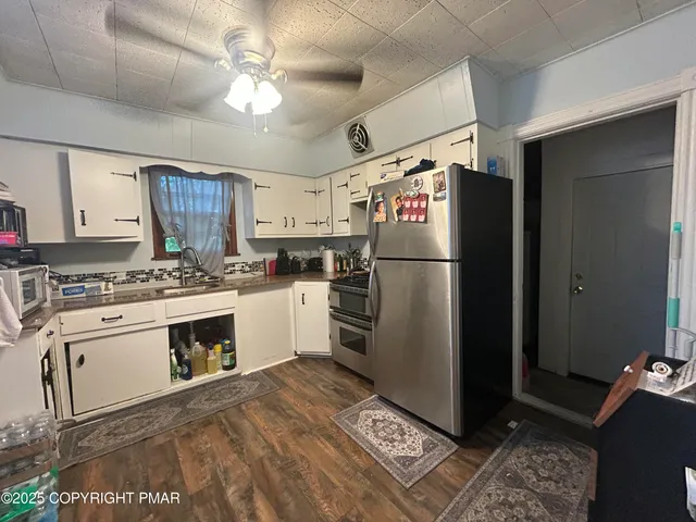 a kitchen with stainless steel appliances a refrigerator sink and cabinets