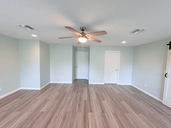 a view of an empty room with wooden floor