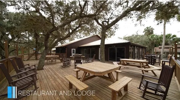 a view of a patio with table and chairs and a barbeque with wooden fence and floor