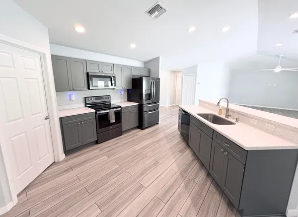 a large kitchen with stainless steel appliances granite countertop a sink dishwasher stove and refrigerator