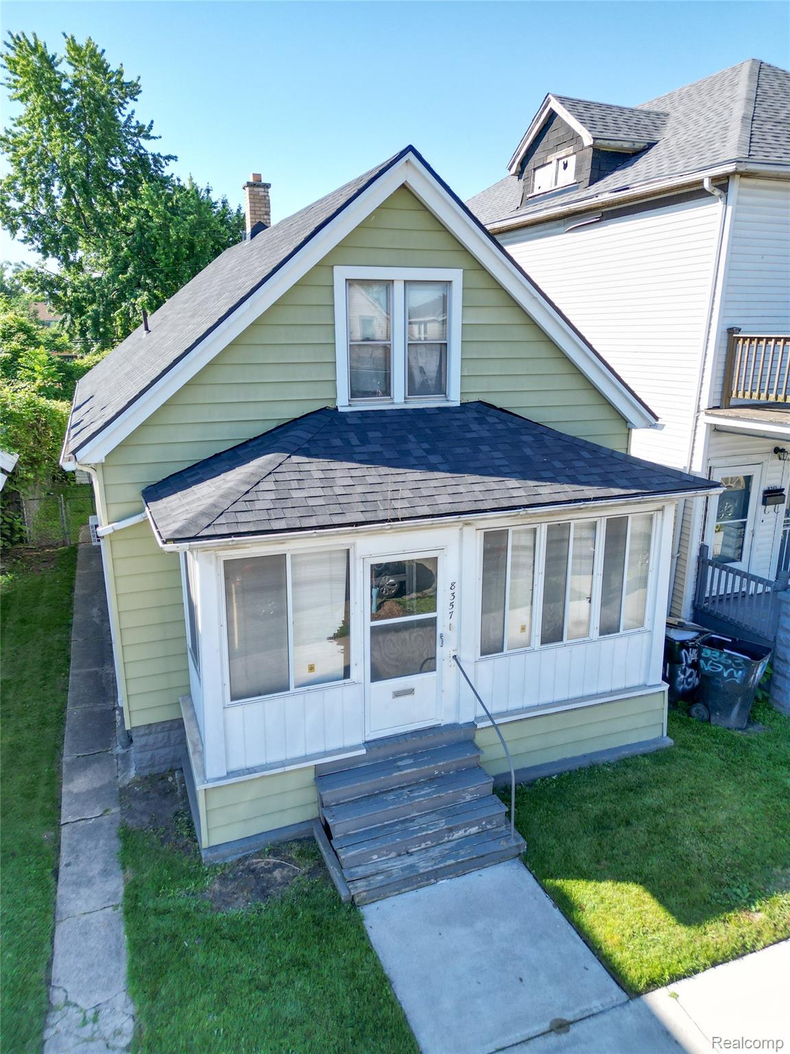 8357 Navy Street Detroit, MI 48209 - Photo 19 of 26 Two-story structure with light green siding and a dark shingle roof
