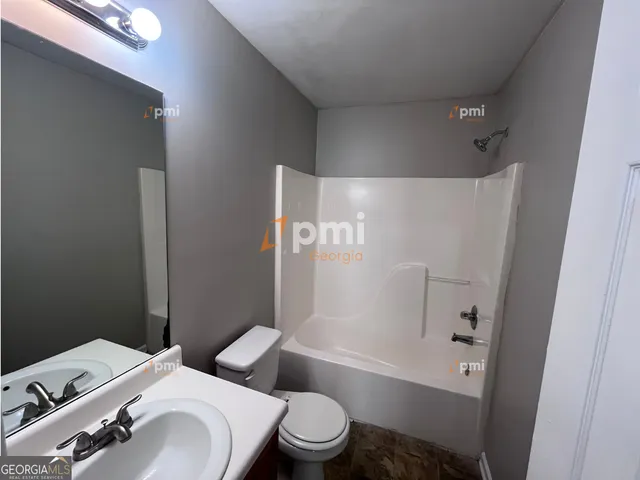 a bathroom with a bathtub sink and mirror