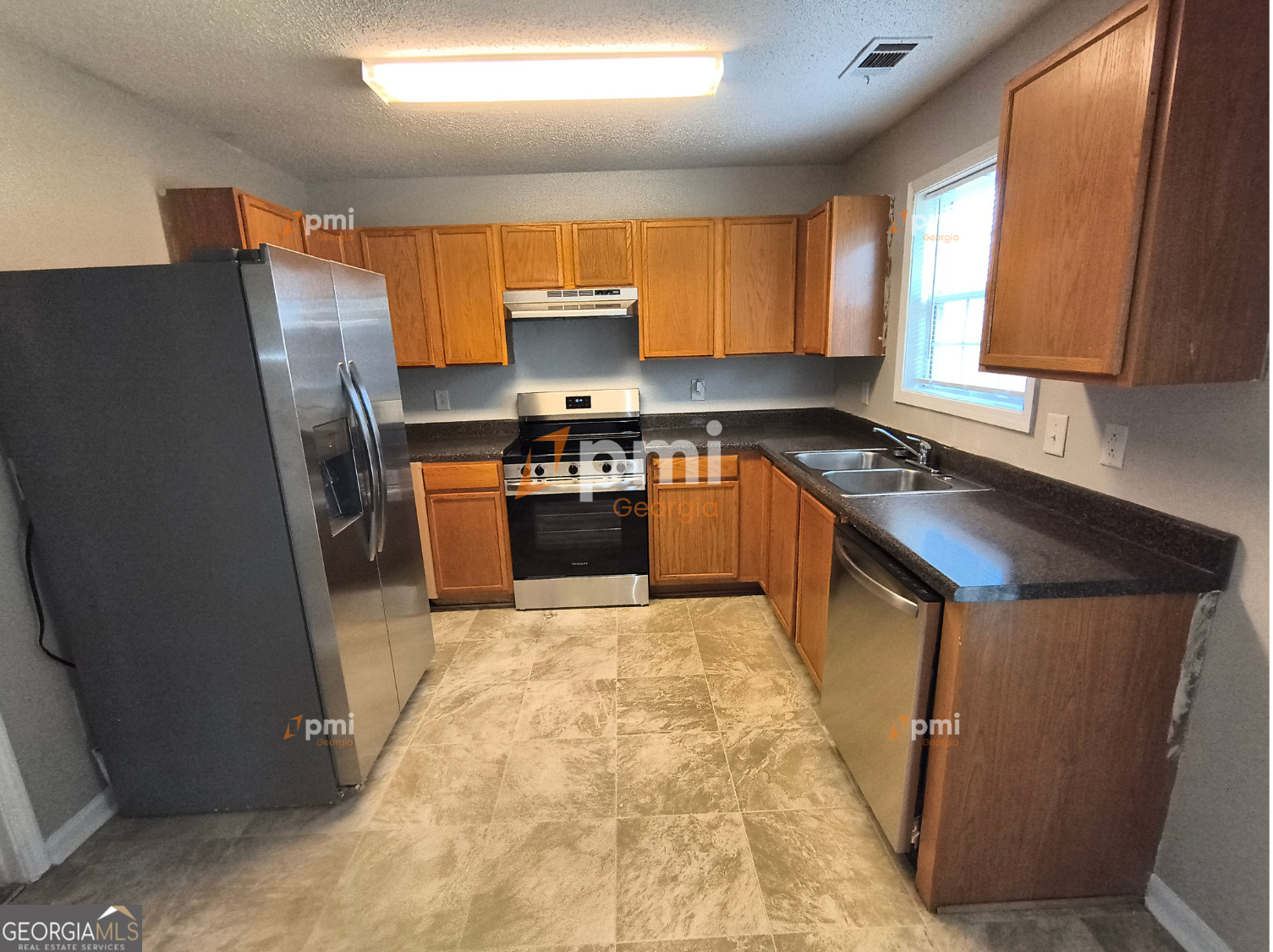 2015 Ivy Lane Union City, GA 30291 - Photo 2 of 18 a kitchen with stainless steel appliances granite countertop a refrigerator stove top oven and sink