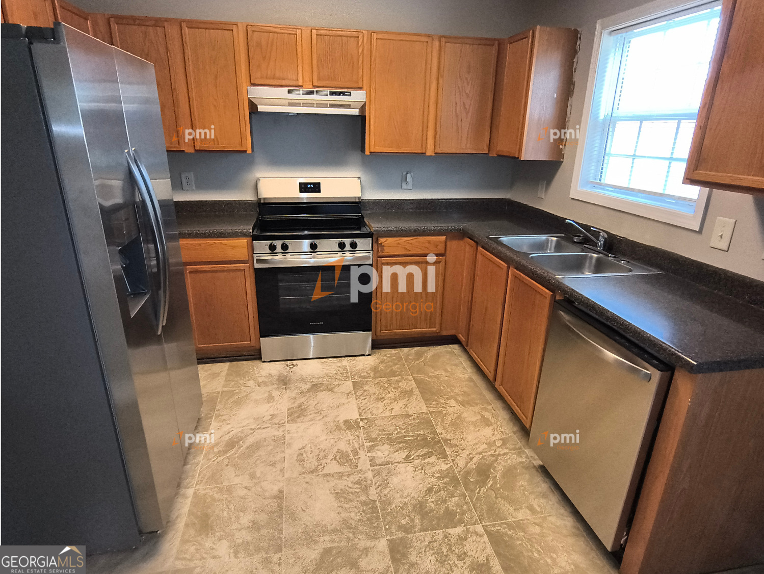 2015 Ivy Lane Union City, GA 30291 - Photo 4 of 18 a kitchen with stainless steel appliances a refrigerator sink and wooden cabinets