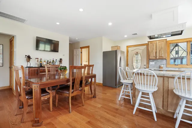 a dining room with furniture window and wooden floor