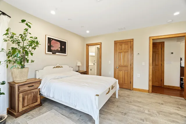 a bedroom with a bed and a potted plant