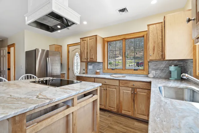 a kitchen with stainless steel appliances granite countertop a sink and a stove