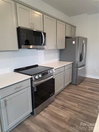 a kitchen with stainless steel appliances a stove a microwave and sink