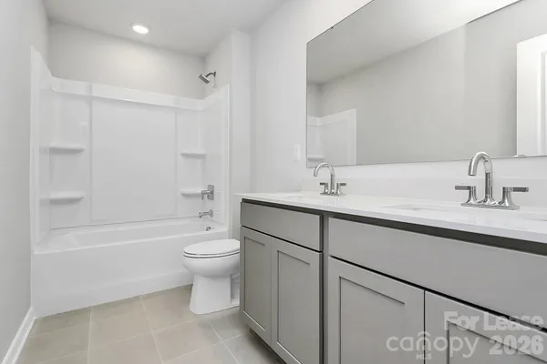 a bathroom with a double vanity sink toilet and shower