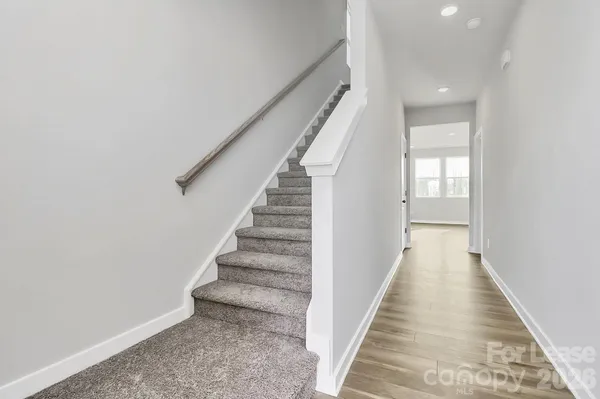 a view of a hallway with wooden floor and entryway