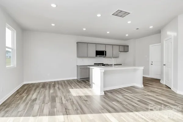 a view of kitchen with wooden floor and electronic appliances