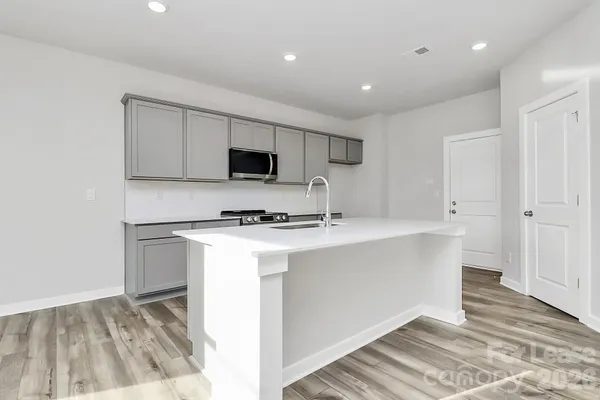 a kitchen with kitchen island a sink appliances and cabinets