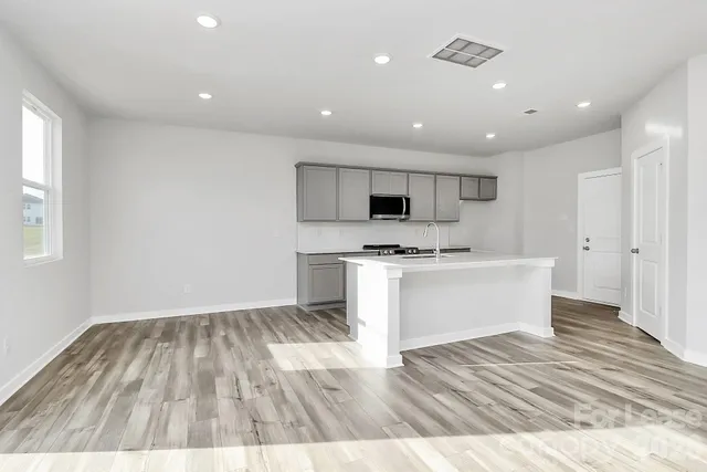 a view of kitchen with wooden floor and electronic appliances