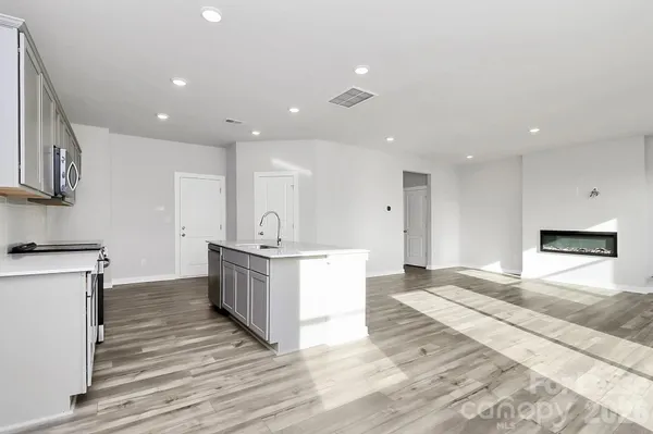 a large kitchen with stainless steel appliances kitchen island a large counter top and a stove top oven