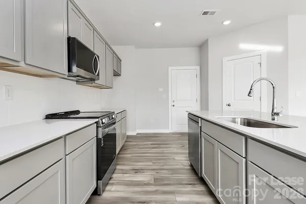 a kitchen with stainless steel appliances granite countertop a sink and a stove