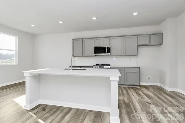 a kitchen with kitchen island a sink appliances and cabinets