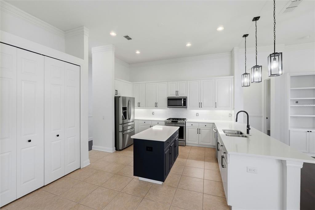 2822 Falcon Ridge Clermont, FL 34711 - Photo 18 of 59 a kitchen with a sink a counter top space stainless steel appliances and cabinets