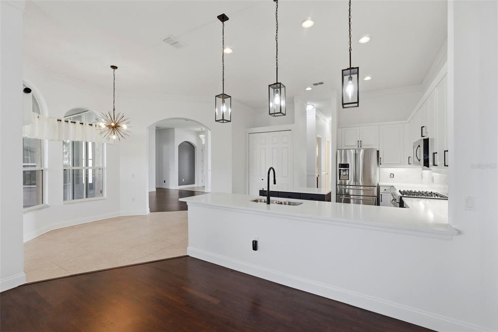 2822 Falcon Ridge Clermont, FL 34711 - Photo 19 of 59 a large kitchen with kitchen island white cabinets and wooden floor