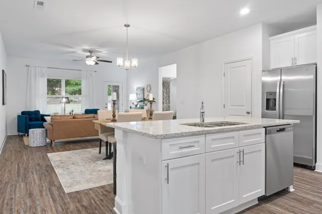a kitchen with kitchen island granite countertop a sink cabinets and stainless steel appliances