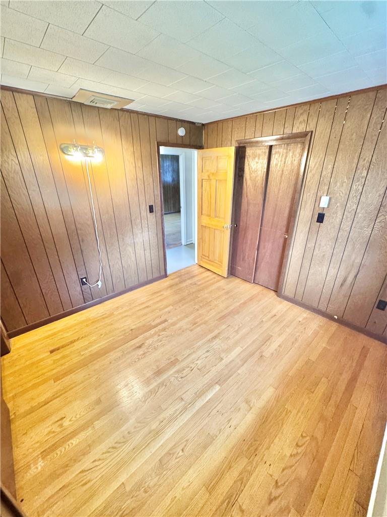 8325 Schantz Road Breinigsville, PA 18031 - Photo 10 of 21 Natural wood paneling and shining hardwood floors create a warm and inviting bedroom space.
