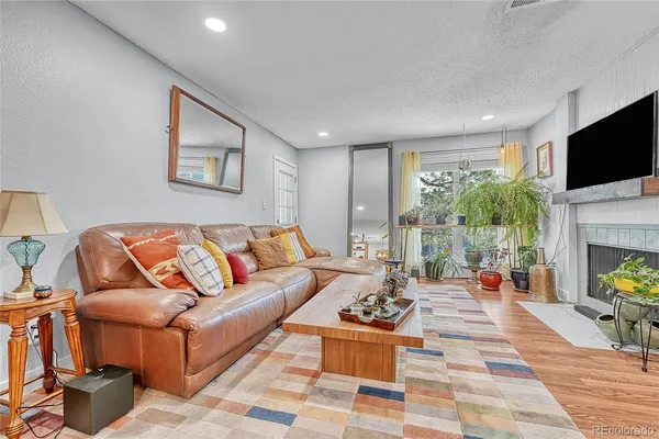 a living room with furniture a fireplace and a flat screen tv
