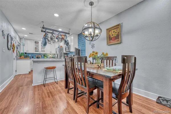 a view of a dining room with furniture a chandelier and wooden floor