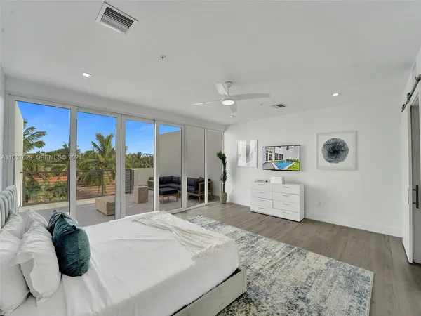 a bedroom with a large bed and a chandelier
