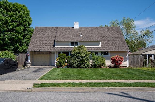 View of front of house with a garage and a front yard