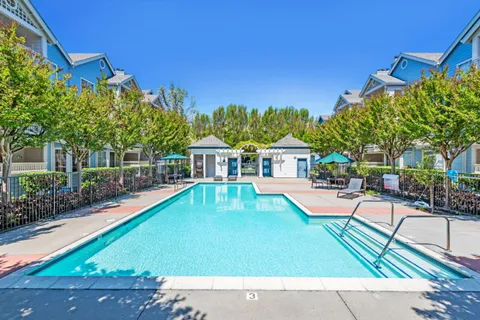 a view of a swimming pool with lounge chairs in patio