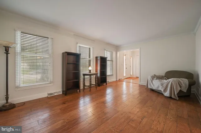 a spacious bedroom with a bed and wooden floor