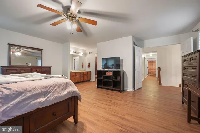 a spacious bedroom with a bed and a flat screen tv