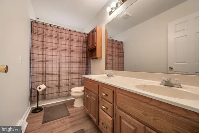 a bathroom with a double vanity sink toilet and shower
