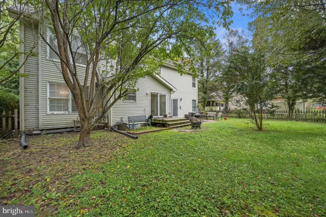 a view of a house with backyard and tree