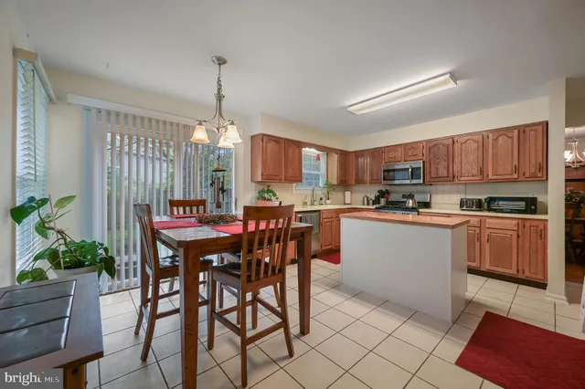 a kitchen with refrigerator a stove a dining table and chairs