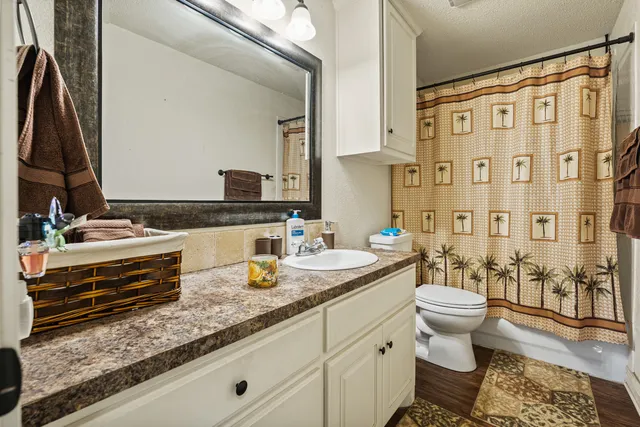 a spacious bathroom with a double vanity sink a mirror a toilet and a shower