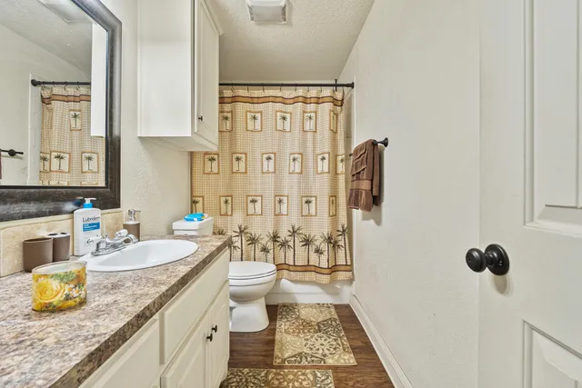 a spacious bathroom with a granite countertop sink and a mirror