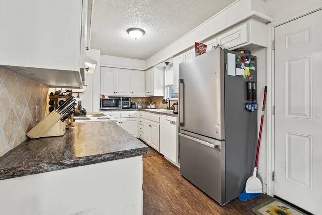 a kitchen with refrigerator and cabinets