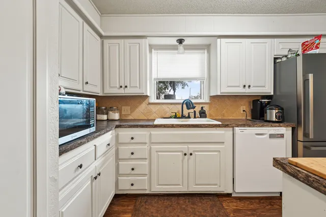 a kitchen with white cabinets and white appliances